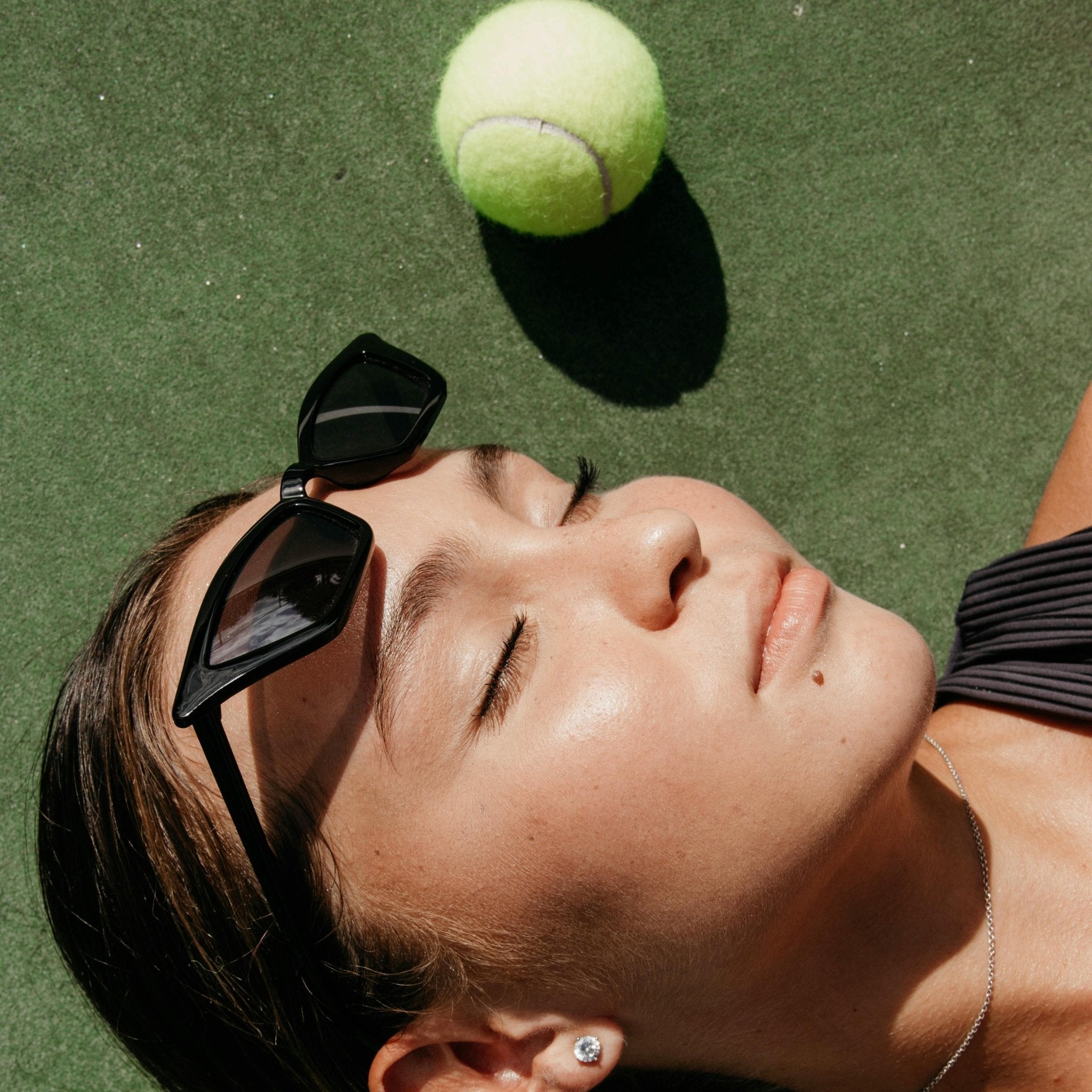 Embracing the Tenniscore Wave: A Rising Trend in Tennis Fashion - Woman in sunglasses in tennis court