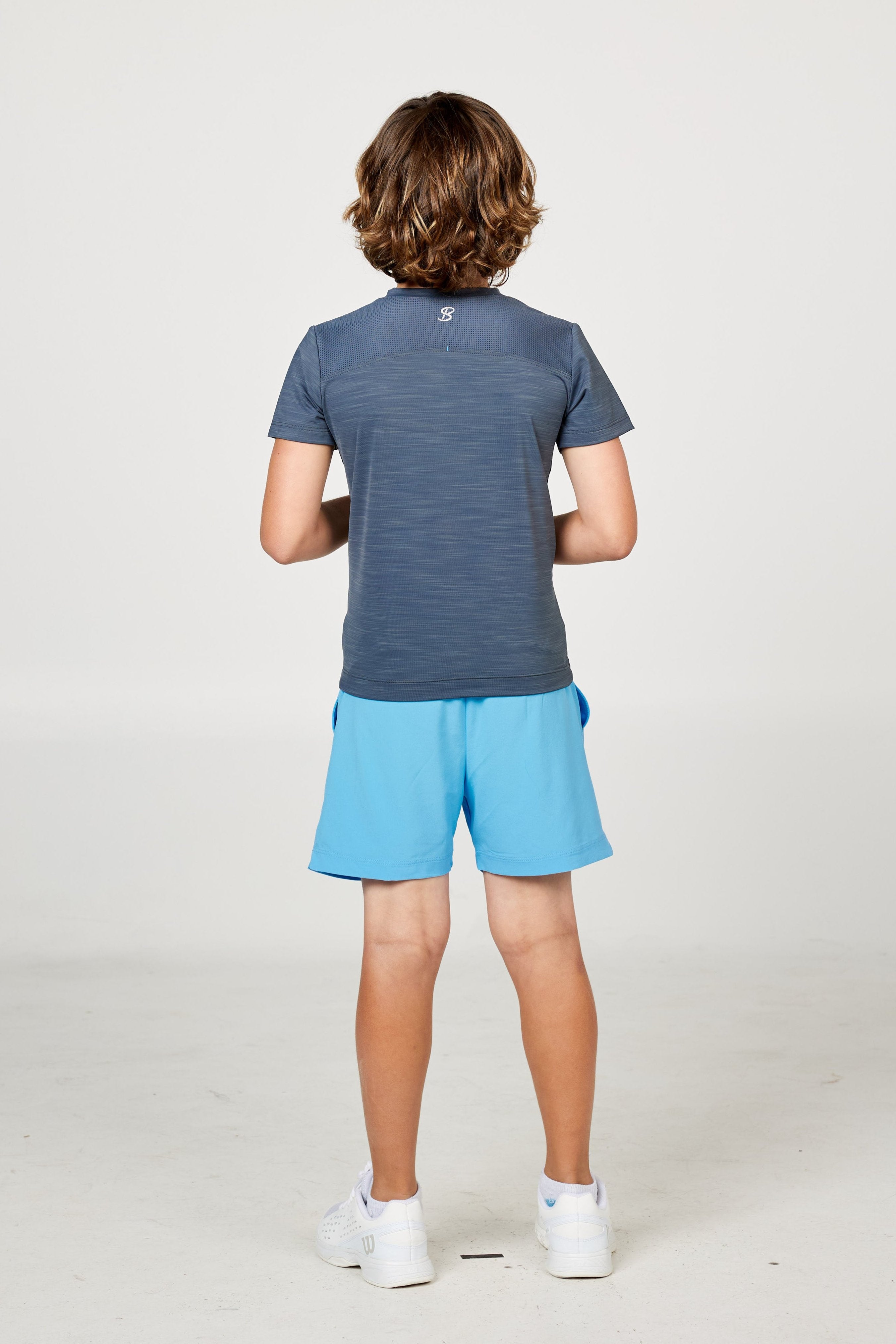 Charcoal boys' short sleeve tennis top by Sofibella, back view on model