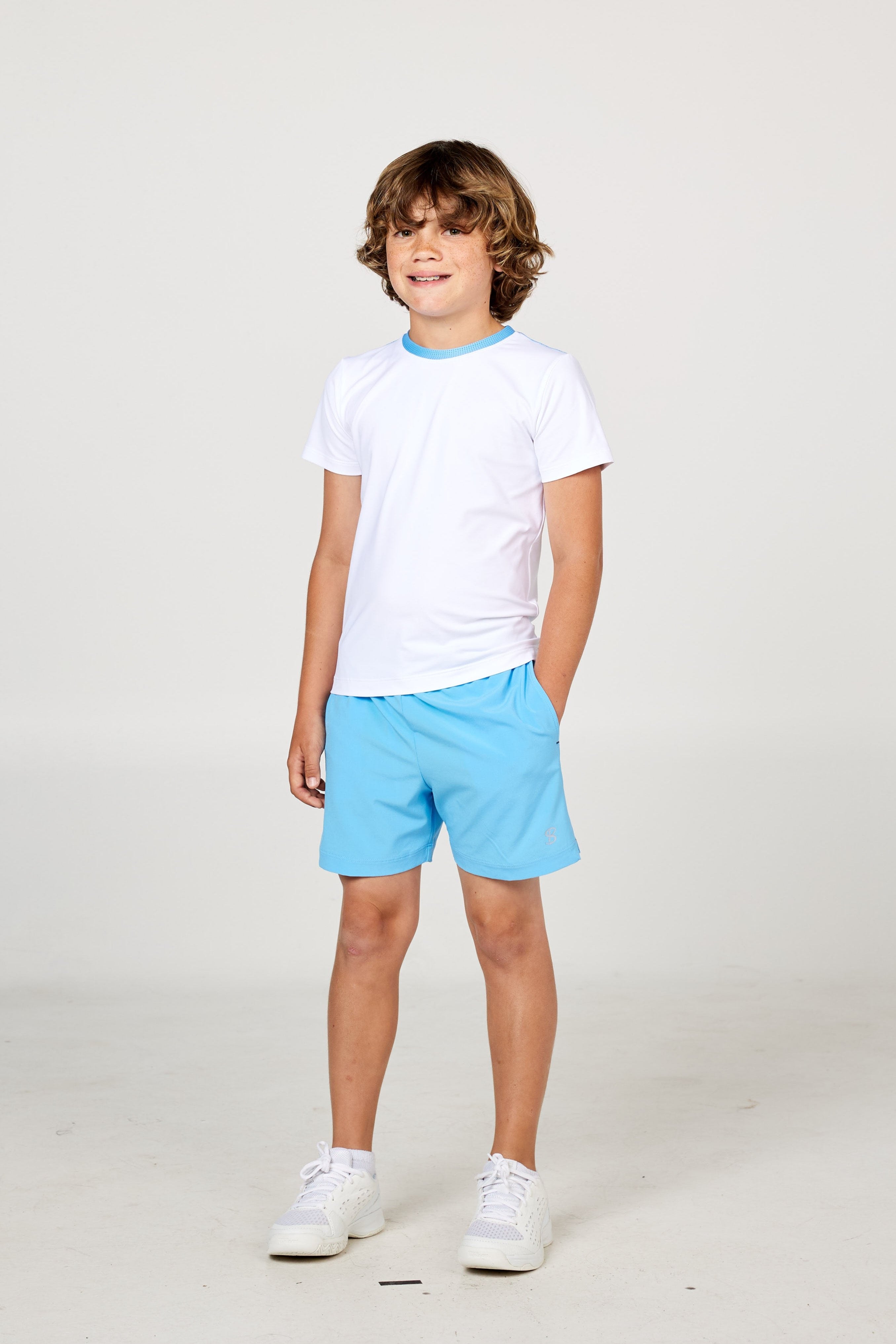 White boys' short sleeve tennis top by Sofibella, front view on model