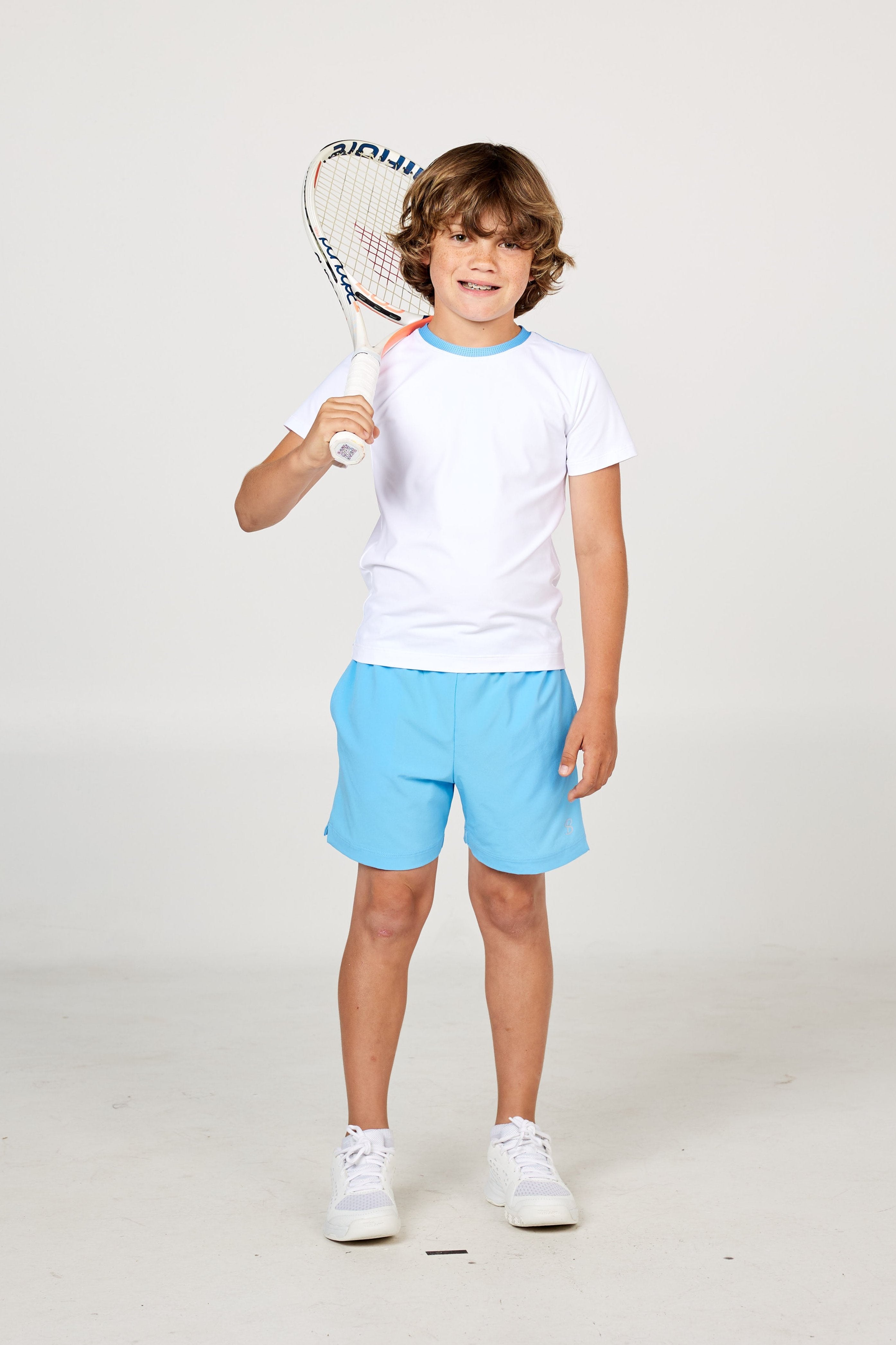 White boys' short sleeve tennis top by Sofibella, front view on model