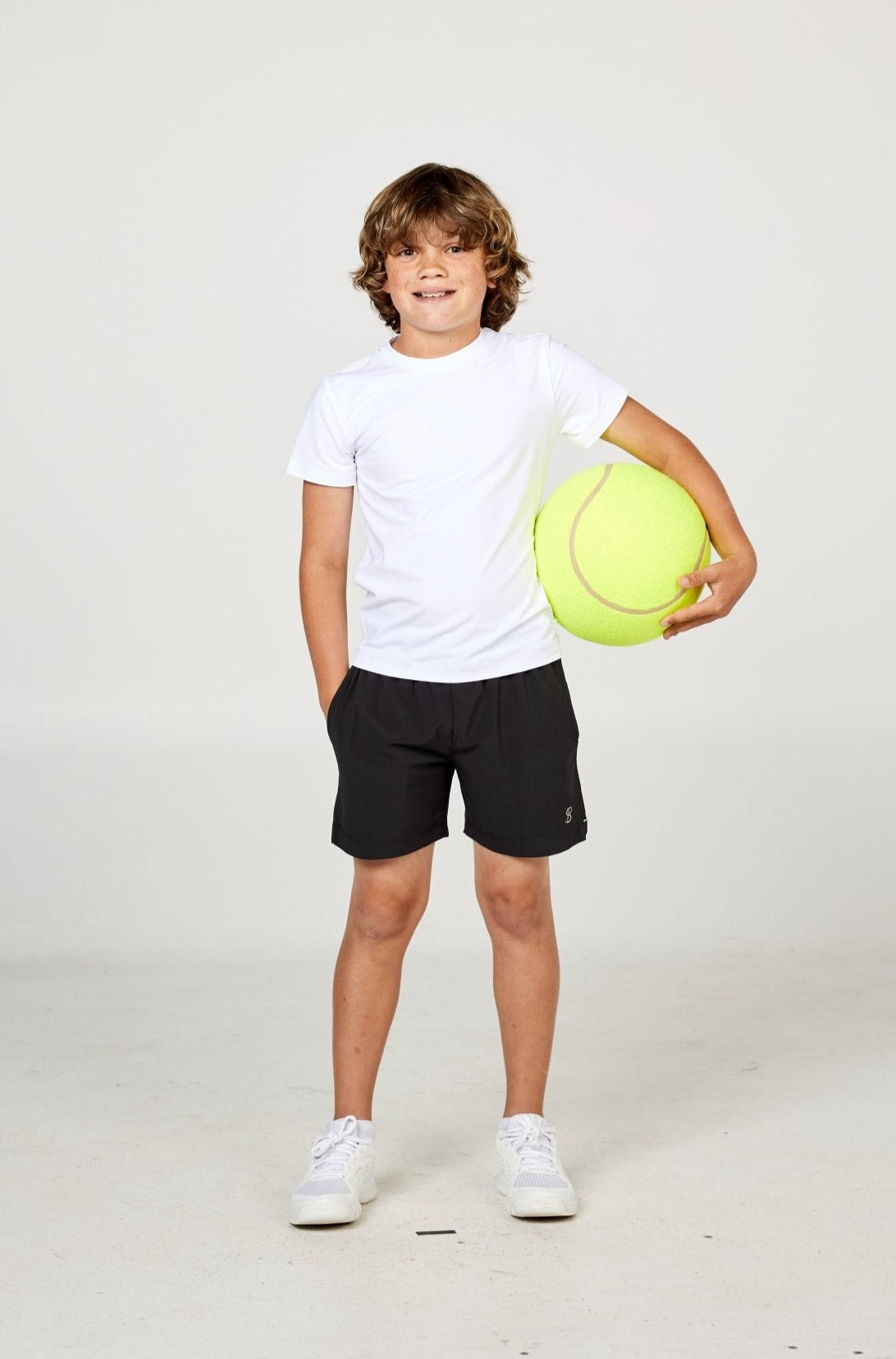 White boys' short sleeve tennis top by Sofibella, front view on model