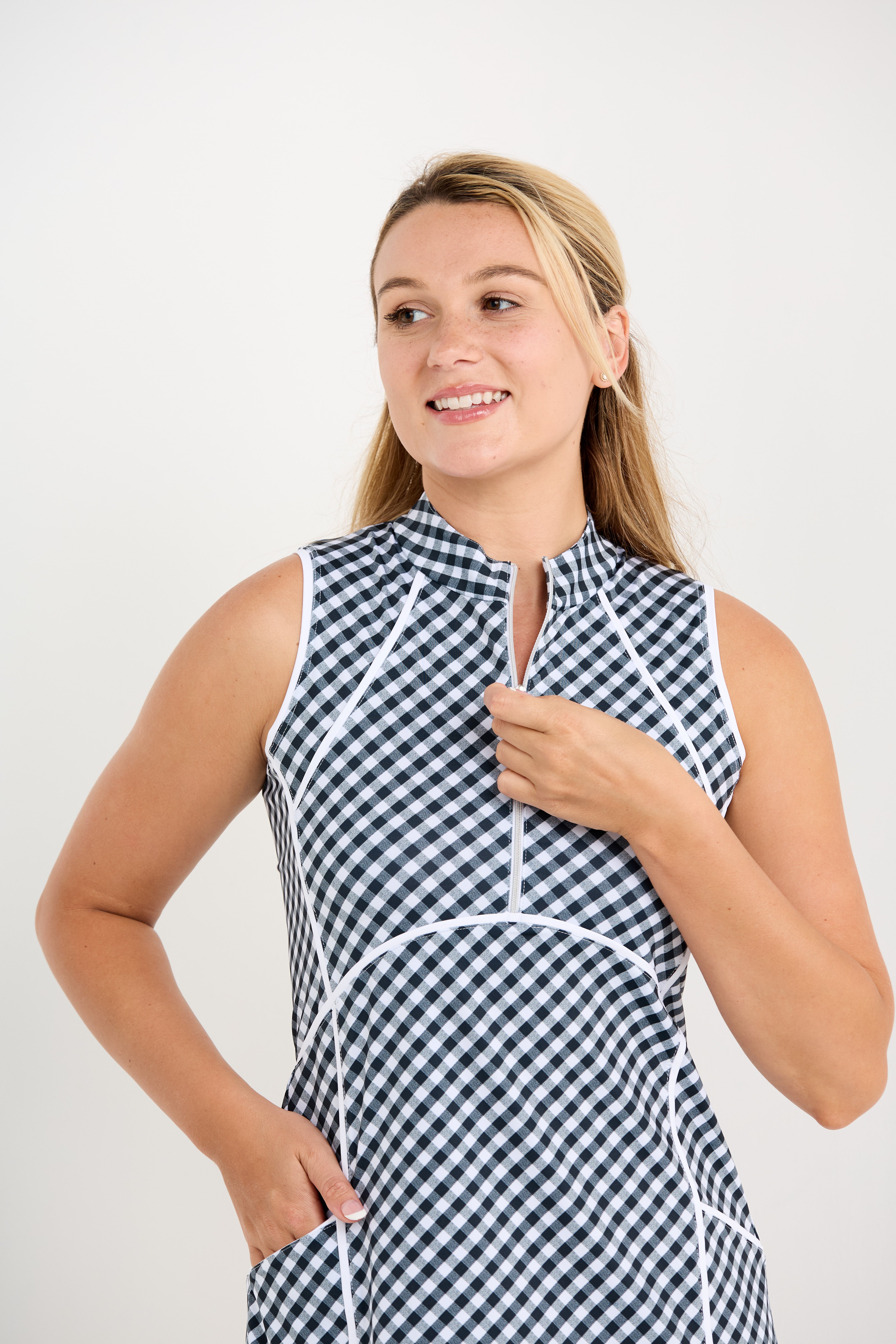 Black and white gingham sleeveless golf dress with zipper front, close up front view