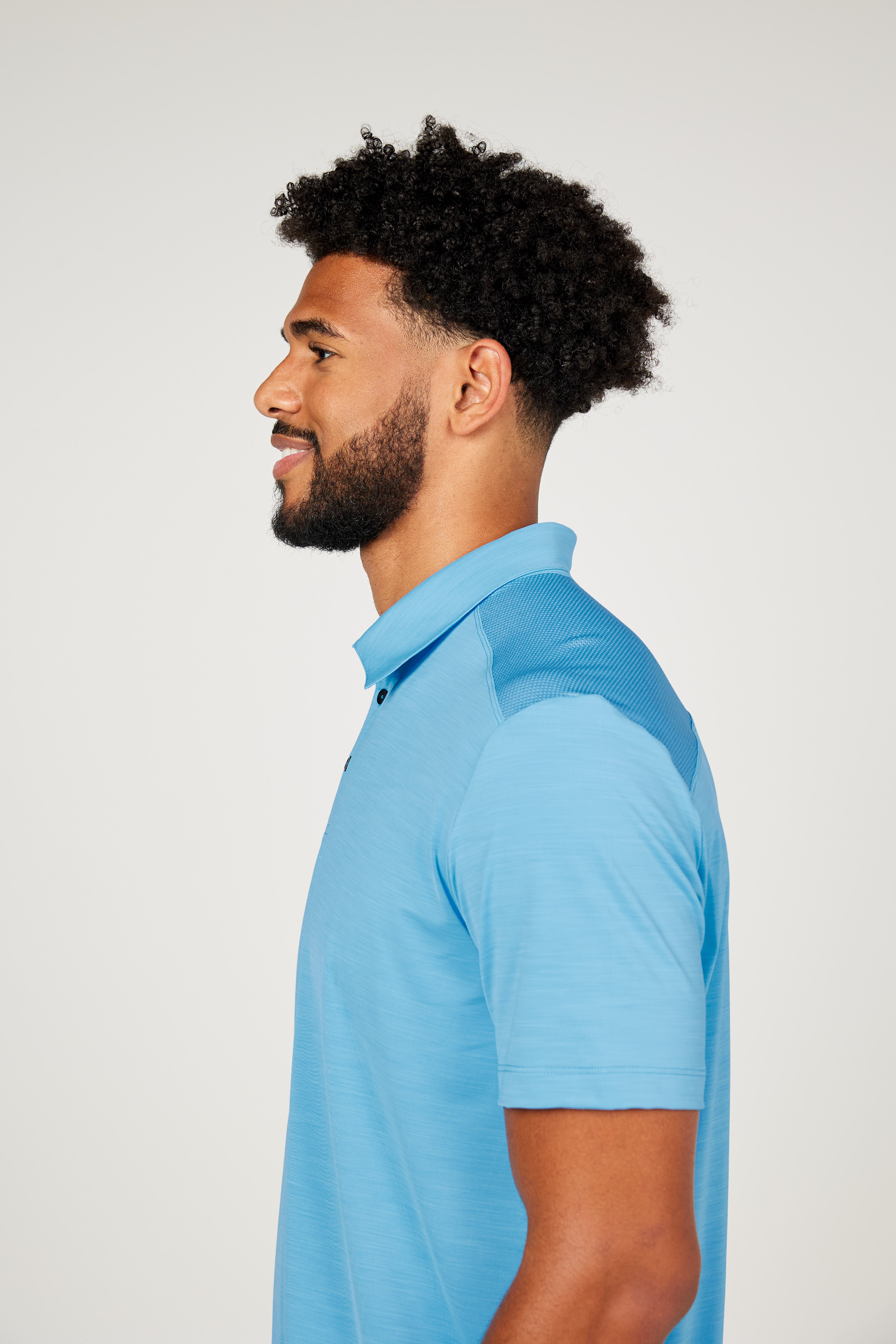 Men's Energy Short Sleeve Neo Blue Polo Tennis Top by Sofibella, side view on model