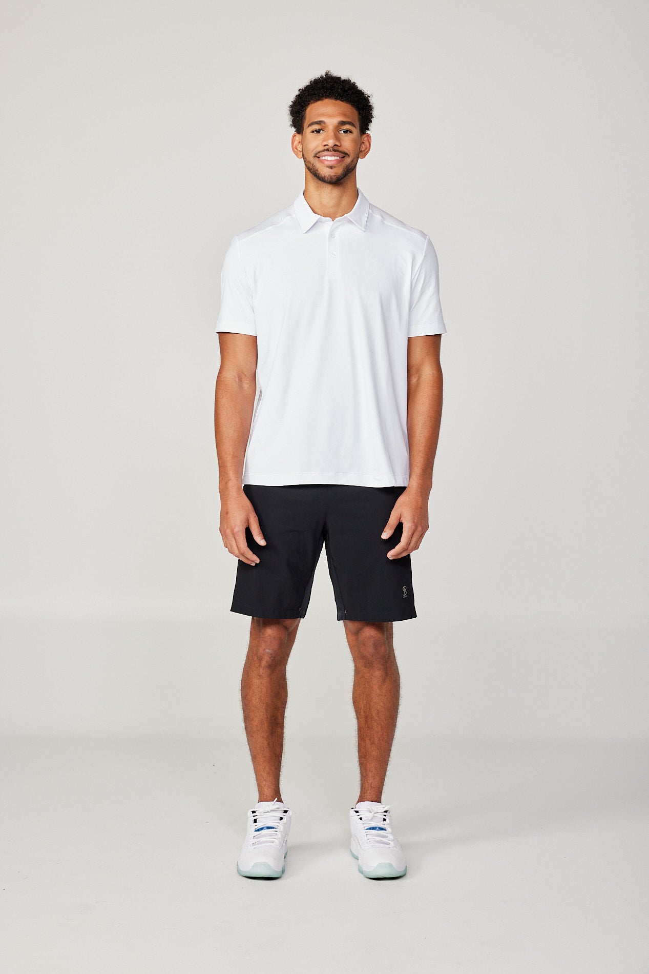 Men's Energy Short Sleeve White Polo Tennis Top by Sofibella, front view on model