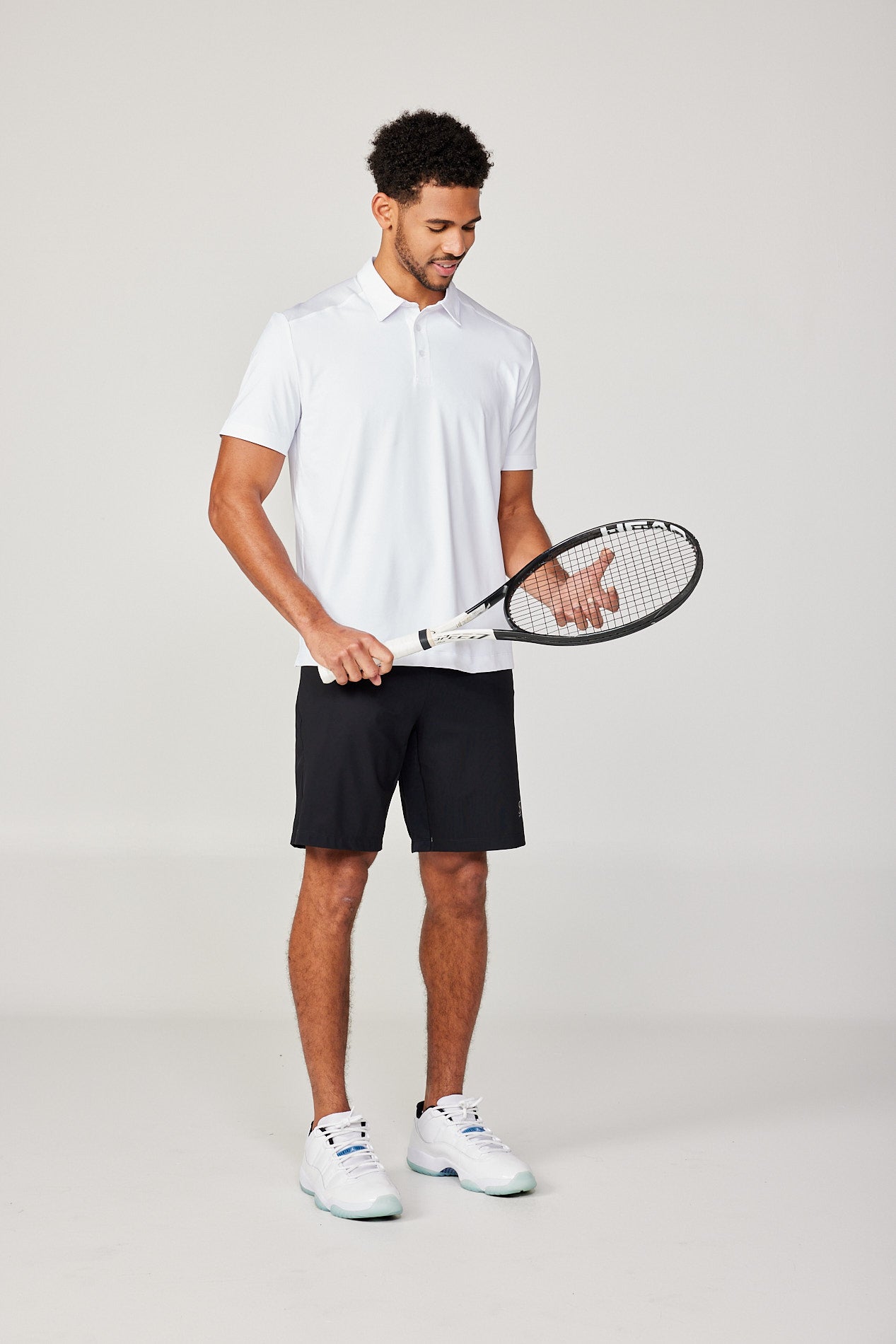Men's Energy Short Sleeve White Polo Tennis Top by Sofibella, front view on model